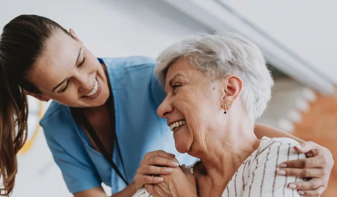 Pflegefachkraft begleitet einen Patienten im häuslichen Umfeld